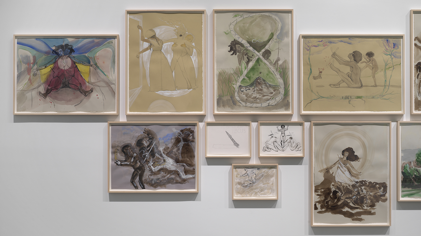 Framed drawings of various sizes and subjects by Kara Walker closely arranged on a museum wall