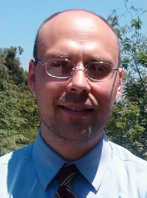 Michael J. Johnson Color photograph of the head of a light skinned man standing outside
