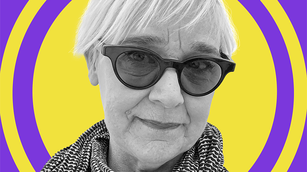 Photo of the face of a light skinned woman wearing sunglasses with concentric purple and yellow circles behind her