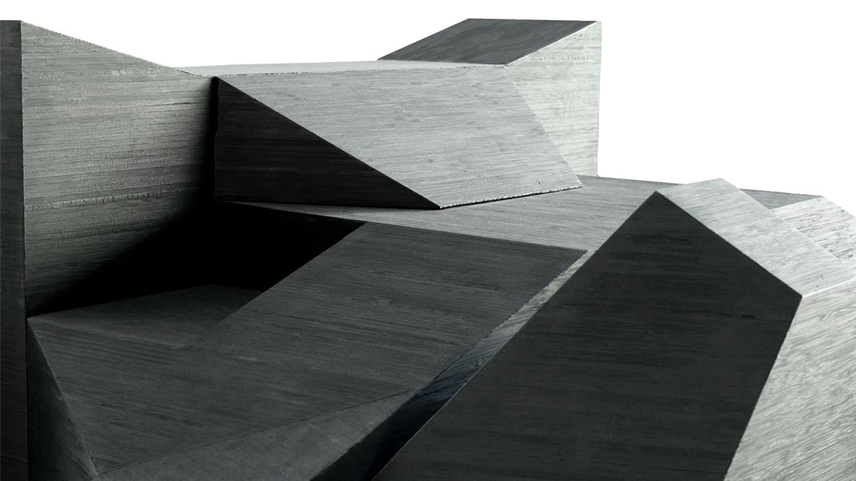 Color photo of a detail of a black geometric sculpture with numerous flat planes
