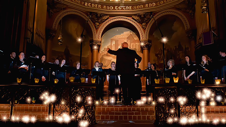 Color photograph of a man conducting a choir in a church