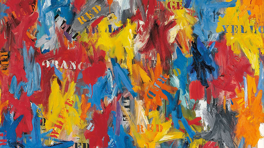 Detail of a painting by Jasper Johns with splotches of red, yellow, blue, and white paint, along with painted words of those same colors