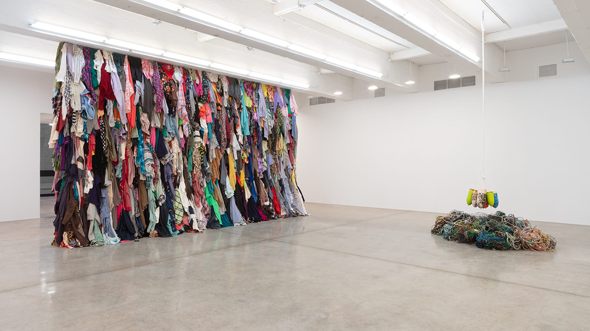 Color photograph of an installation of fabric works by Karyn Oliver in an indoor white cube gallery