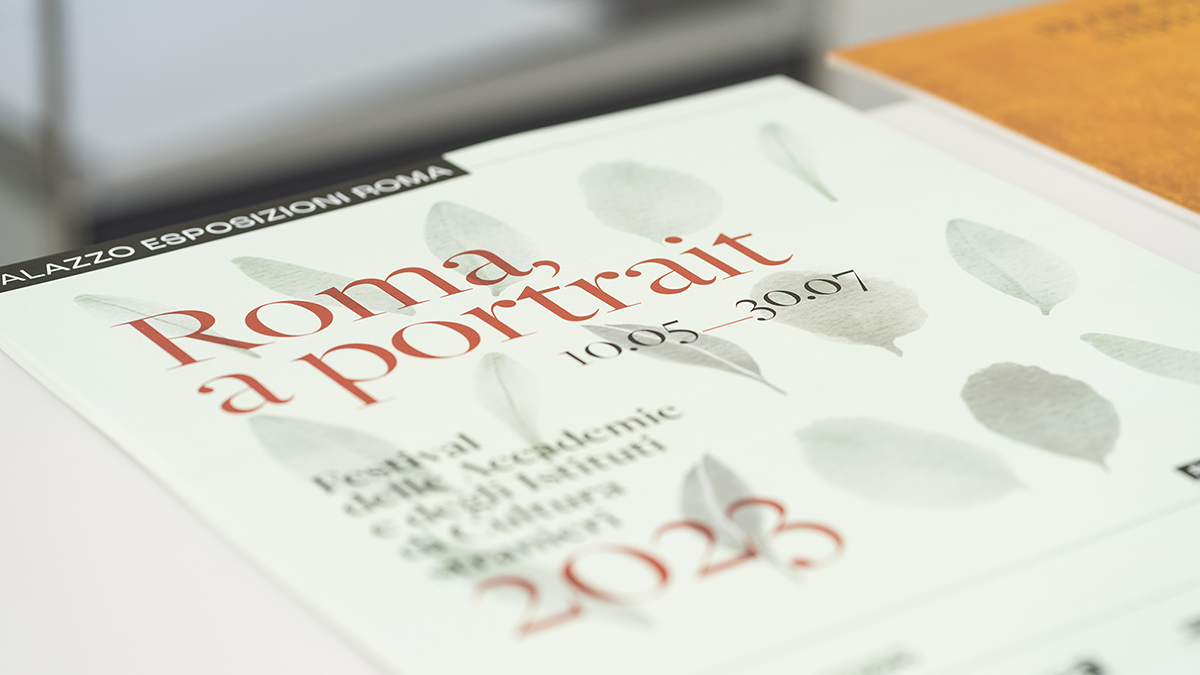 Color photograph depicting the cover of a program for an exhibition; printed on paper is the exhibition's title: Roma, a Portrait