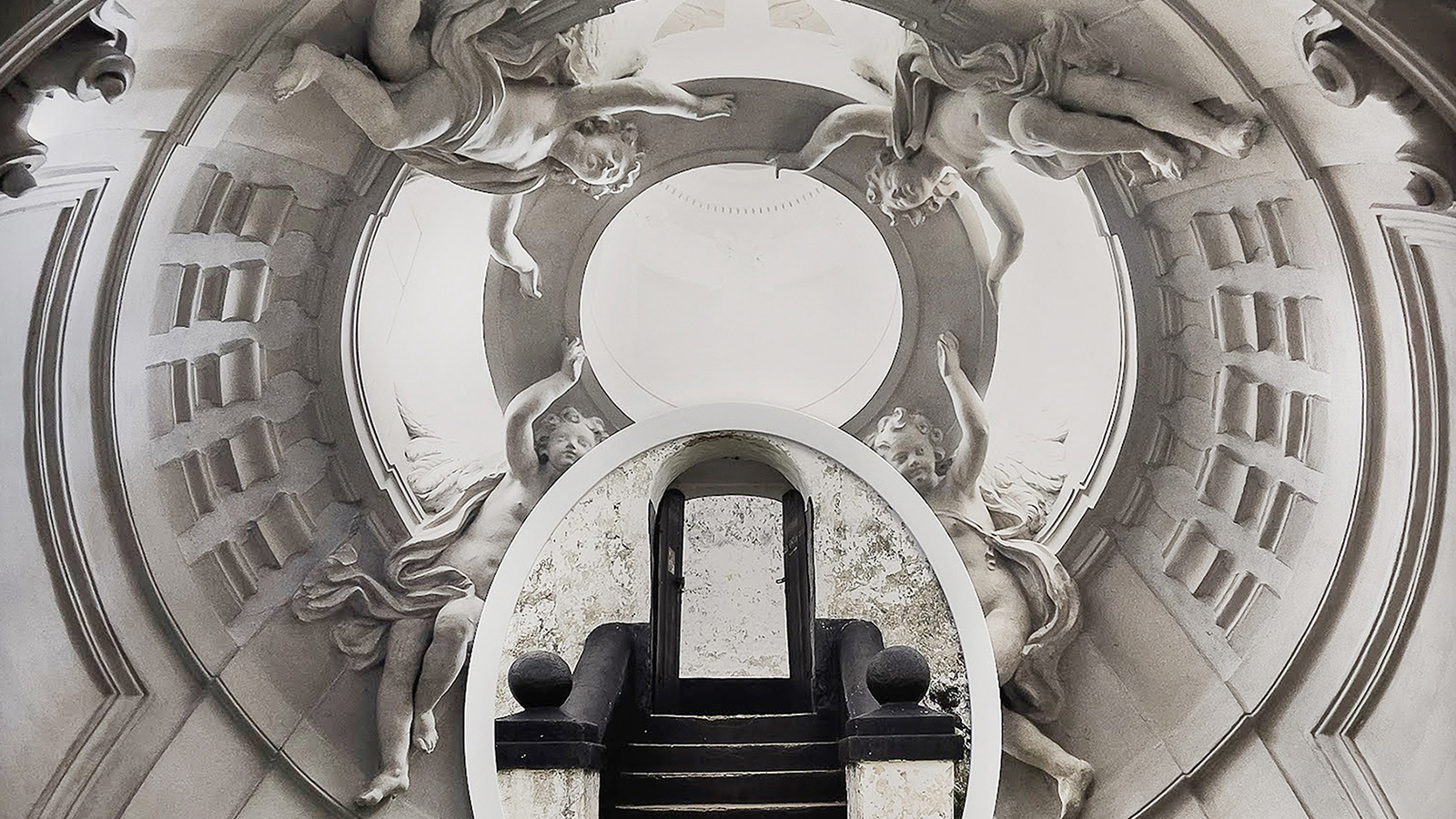 Collage of two black and white photographs: a round cutout of a short exterior building staircase and archway is superimposed on a view of a baroque church oculus with sculpted cherubs
