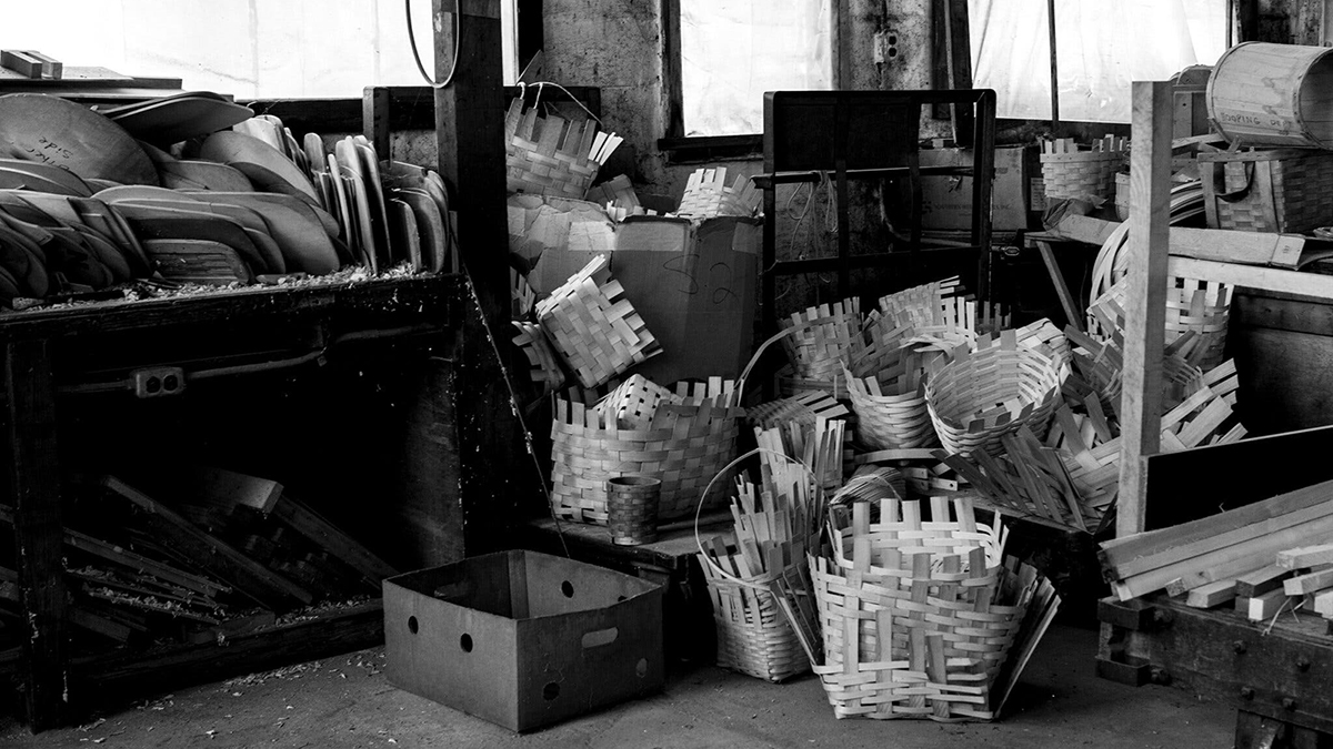 Black and white photograph of wooden baskets in a rustic interior