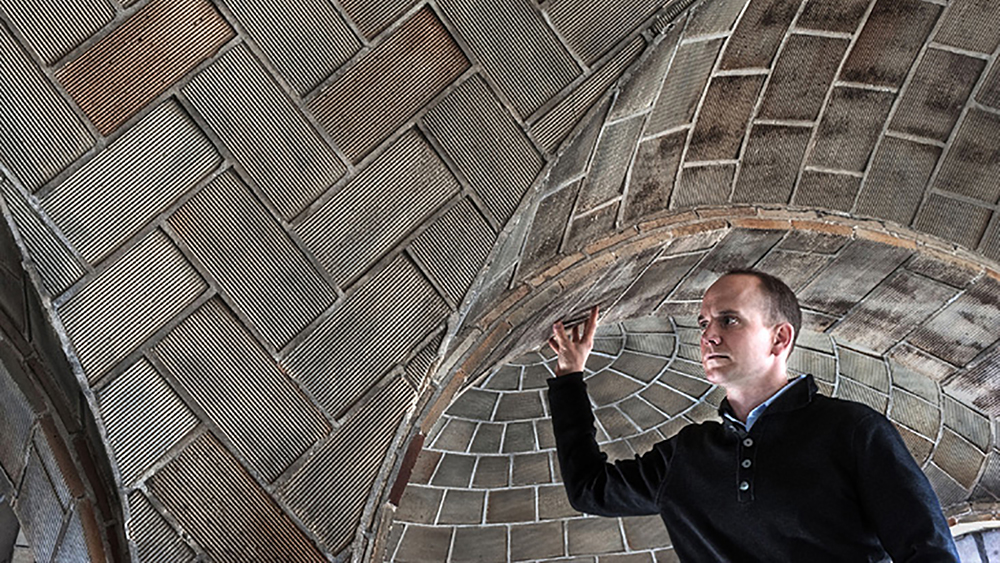 Color photograph of John Ochsendorf under a low vaulted stone ceiling